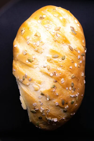 A loaf of white bread with seeds is insulated against a black background. — Stock Photo, Image