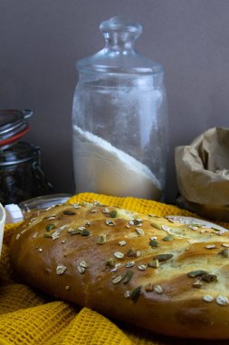 Tahta masanın üzerinde yumurta, un, tohum ve fındıklı ekmek var..