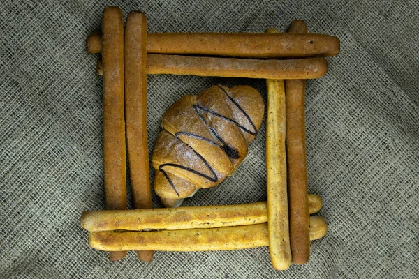 กองไม้ขนมปังหรือกรีซินี่ในรูปร่างของสี่เหลี่ยมภายในครัวซองต์ — ภาพถ่ายสต็อก