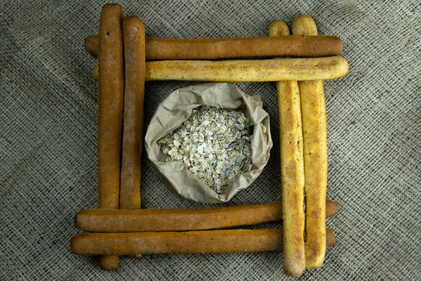 Uma pilha de paus de pão ou grissini na forma de um quadrado dentro de um pacote com aveia — Fotografia de Stock