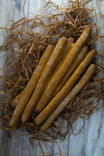 Concept shot of μπαχαρικά ψωμί sticks σταθεί σε ξηρό γρασίδι. — Φωτογραφία Αρχείου