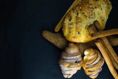Siyah kırsal arka planda tahıllı farklı türde taze ekmek..