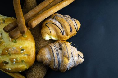 Siyah kırsal arka planda tahıllı farklı türde taze ekmek..