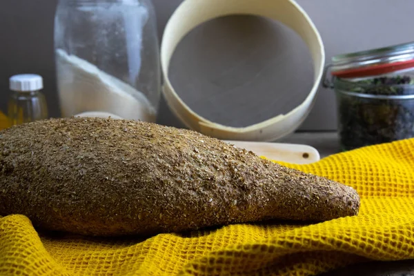 背景の黄色のタオルの上のオートミールダイエットパンは、小麦粉、小麦粉、スパイスとスプーンの瓶のために満足している. — ストック写真