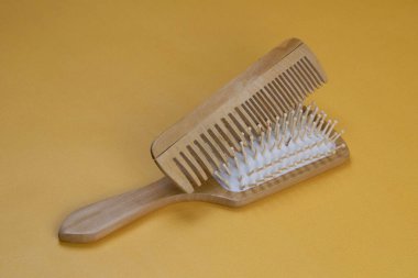 Kozmetik ürünleri, kokoba, argan ya da hindistan cevizi yağı. Turuncu arka planda yağ şişeleri ve taraklar.