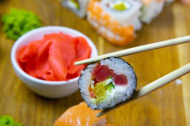 Çadırlarda tahtanın üzerinde zencefil, wasabi ve diğer rulolarla bir rulo var.