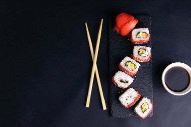 Suşi için granit tezgahta yuvarlanırlar. Suşi ve soya sosunun yanında ejderha şeklinde dururlar..