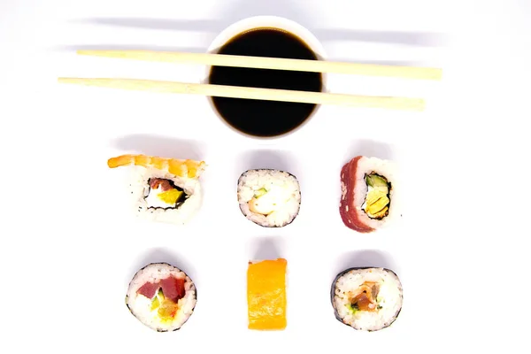 Zestaw rolek różnego rodzaju z sosem sojowym i pałeczkami sushi izolowane na czarnym tle — Zdjęcie stockowe