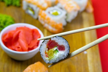 Çadırlarda tahtanın üzerinde zencefil, wasabi ve diğer rulolarla bir rulo var.