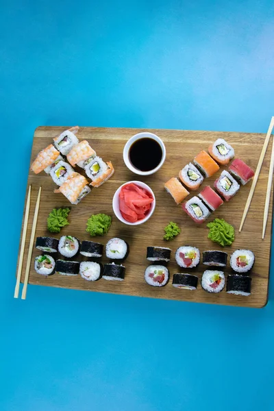 Vista dall'alto del piatto di legno con una grande serie di deliziosi sushi Nigiri e rotoli Tempura con rotoli Maki e Uramaki — Foto Stock