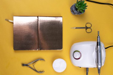 Set of cosmetic tools for manicure and pedicure on an orange background. Gel polishes, cutters, nail files, scissors and nippers.