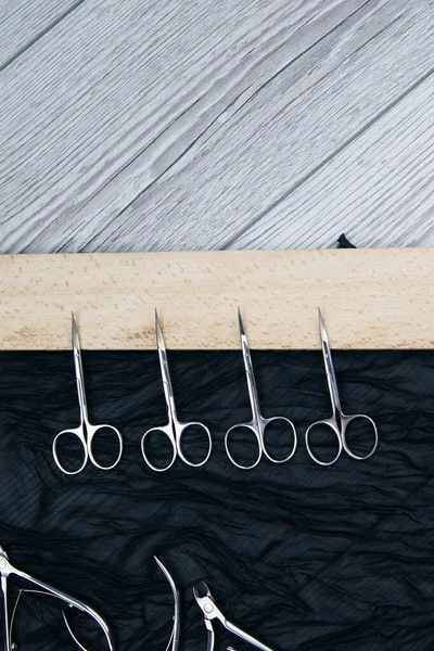 Conjunto de herramientas cosméticas para manicura y pedicura sobre fondo negro. tijeras y pinzas . — Foto de Stock