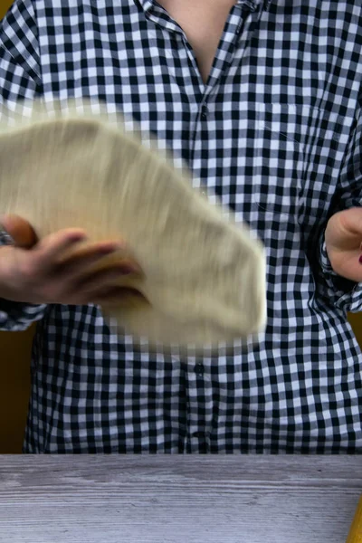 Woman tossing a slice of pizza dough. Fresh original italian raw pizza. Preparatory process — Stock Photo, Image