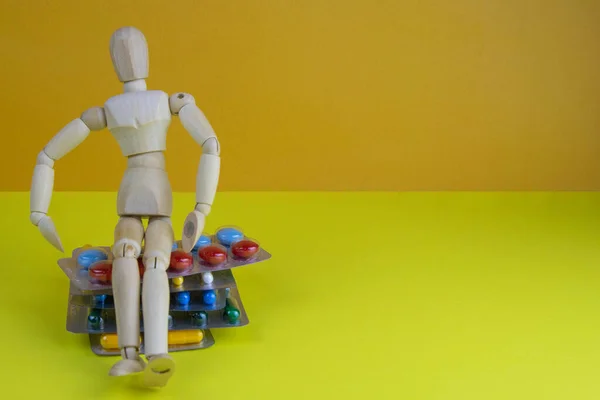 Drewniana Figurka Zabawki Tabletkami Żółtym Tle Różne Kapsułki Tabletki Lekarstwa — Zdjęcie stockowe
