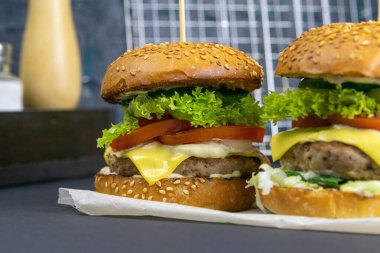 Arka planda iki hamburger, bir ızgara..