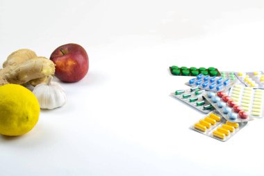 Limon, zencefil, çok renkli tabletlere karşı bir şapel ve elma. Sağlıklı bir diyet ile ilaç alma kavramı. Açık alanlı en üstteki görünüm