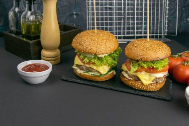 Arka planda iki hamburger, bir ızgara..