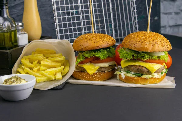 Dois Hambúrgueres Close Nas Proximidades São Batatas Fritas Tomates Molhos — Fotografia de Stock