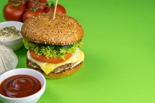 Hamburgers Close Een Groene Achtergrond Buurt Zijn Frietjes Sauzen Tomaten — Stockfoto