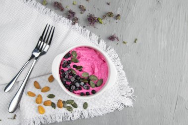 Reçelli süzme peynir, taze yaban mersini ve kabak tohumları seramik kasede, yakın plan. Lezzetli ve sağlıklı kahvaltı..