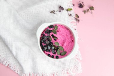 Reçelli süzme peynir, taze yaban mersini ve kabak tohumları seramik kasede, yakın plan. Lezzetli ve sağlıklı kahvaltı..