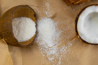 Kırık hindistan cevizleri kağıt üzerinde, pembe arka planda duruyor..