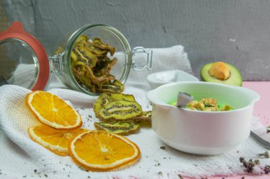 Avokado ve kiviyle kaymak. Sağlıklı beslenme konsepti. Pembe arka planda kaselerde çeşitli ürünler.