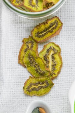 Sağlıklı atıştırmalıklar. Gri arka planda ev yapımı kurutulmuş meyve cipsi. Kuru kivi..