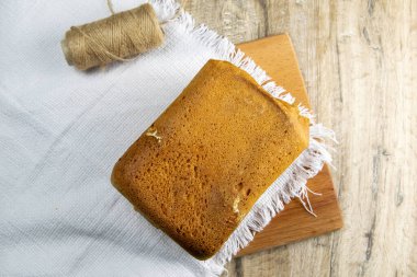 Taze ev yapımı ekmek tahta bir tahtanın üzerinde beyaz bir havlu üzerinde duruyor. Üst Görünüm.