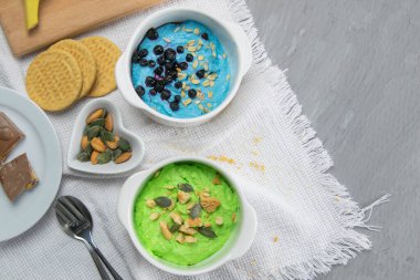 Biri yabanmersini ve fındıklı, diğeri avokado ve kivili, yanında balkabağı tohumu ve fındık var..