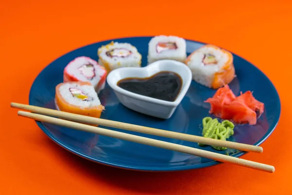 Niebieska Płyta Sushi Wypełniona Rolkami Różnego Rodzaju Obok Stojaków Sushi — Zdjęcie stockowe
