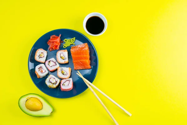 Kék Tányér Sushi Val Különböző Tekercsekkel Töltve Mellette Pálcika Sushi — Stock Fotó