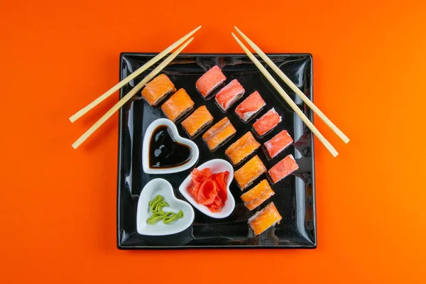 Fekete Tányér Sushi Val Különböző Tekercsekkel Töltve Mellette Pálcikák Sushi — Stock Fotó