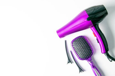 Beyaz arka planda profesyonel erkek çantası, mor saç kurutma makinesi, saç tokası ve lahanası..