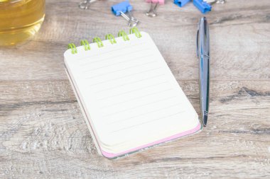 Üzerinde gümüş bir kalem olan defter..