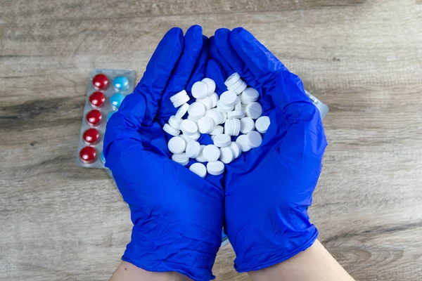 Många Små Vita Piller Läkarens Händer Klädda Medicinska Blå Engångshandskar — Stockfoto