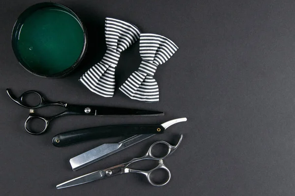 Shaving gel, dangerous razor and white in black stripe butterfly on black background. Hairdressing concept.