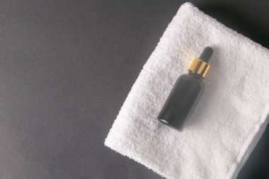 El yağı ve siyah arka planda duran beyaz bir havlunun üzerinde durmak. Düz yatıyordu. Boşluğu kopyala.