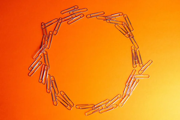 Συσκευασία Χρωματιστών Συνδετήρων Από Χαρτί Τοποθετημένοι Κύκλο Πορτοκαλί Επιφάνεια — Φωτογραφία Αρχείου