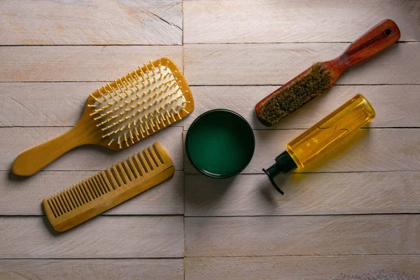 Hair gel and comb for haircut stand on a white table. Hairdressing concept.