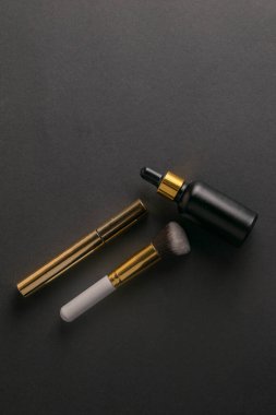 El yağı, kirpik gölgeleri ve siyah bir masanın üzerindeki meikap fırçası standı. Düz yatıyordu. Boşluğu kopyala.