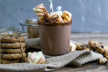 Marşmelovlu kakao, çikolatalı fırın ve ahşap bir masada duran çikolata dilimleri..