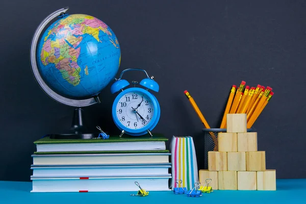 Wereldbol Klok Staan Een Stapel Boeken Naast Een Glas Potloden — Stockfoto