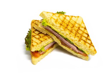 Çekici, gülümseyen bir kadın, tipik bir Amerikalı anne, mutfağında salam, peynir, salata, salata, salata ve beyaz arka planda izole edilmiş domateslerle taze sağlıklı sandviçler hazırlıyor.