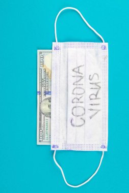 Coronavirus Wuhan. ABD karantinası, 100 dolarlık banknot ve üzerinde koronavirüs yazan tıbbi maske. Salgın ve Coronavrius 'a karşı koruma kavramı..