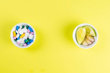 Kireç ve zencefil, çok renkli tabletlere karşı. Sağlıklı bir diyet ile ilaç alma kavramı. Açık alanlı en üstteki görünüm.