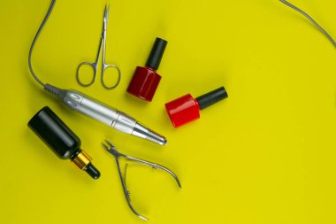 Manikür ve pedikür için kozmetik aletler. Manikür makası, tırnak eti, testere, değirmenci yalın arka planda duruyor. Açık alanlı en üstteki görünüm.