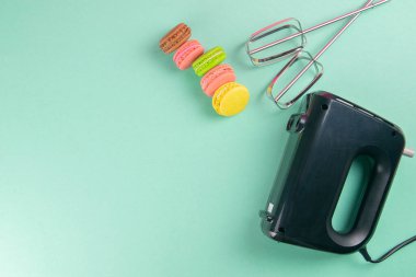 Renkli badem kurabiyeleri ve nane arkaplanda mikser. Açık alanlı en üstteki görünüm.