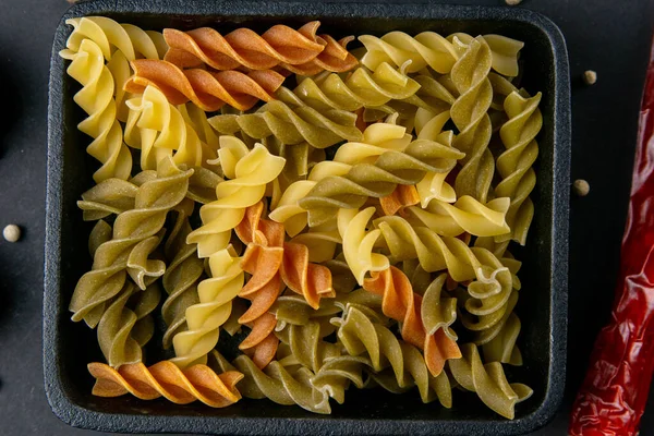 Italian food raw pasta fusilli in a small frying pan. Top views, close-up, macro photography.