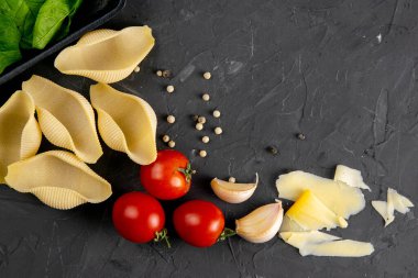 Makarna, büyük koni ve taze sebze. İtalyan mutfağı için malzemeler, üst manzara. Boşluğu siyah tahta arkaplanda kopyala.